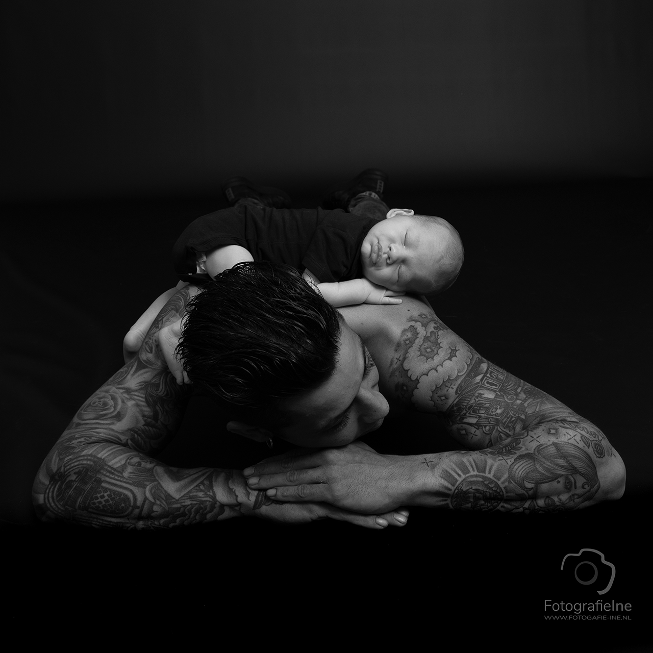 Fotografie Ine newborn fotoshoot baby op rug zwart wit